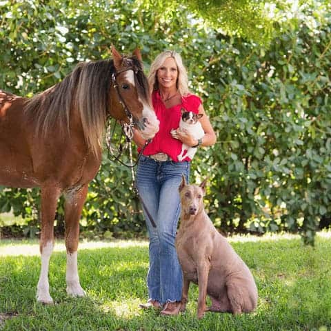 Vickie Miller with dogs and horse